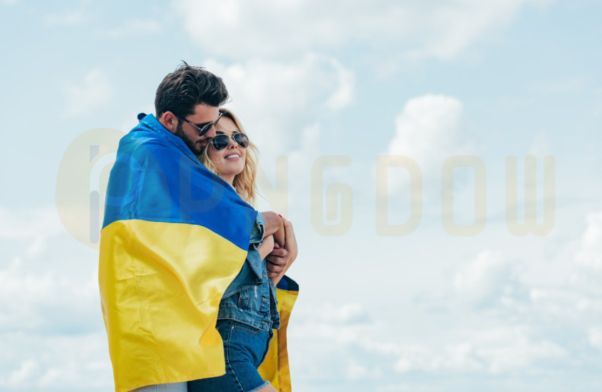 attractive woman and handsome man smiling and holding ukrainian flag