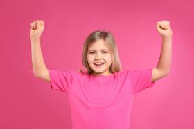 Happy Little Girl Wearing Casual Outfit on Pink Background